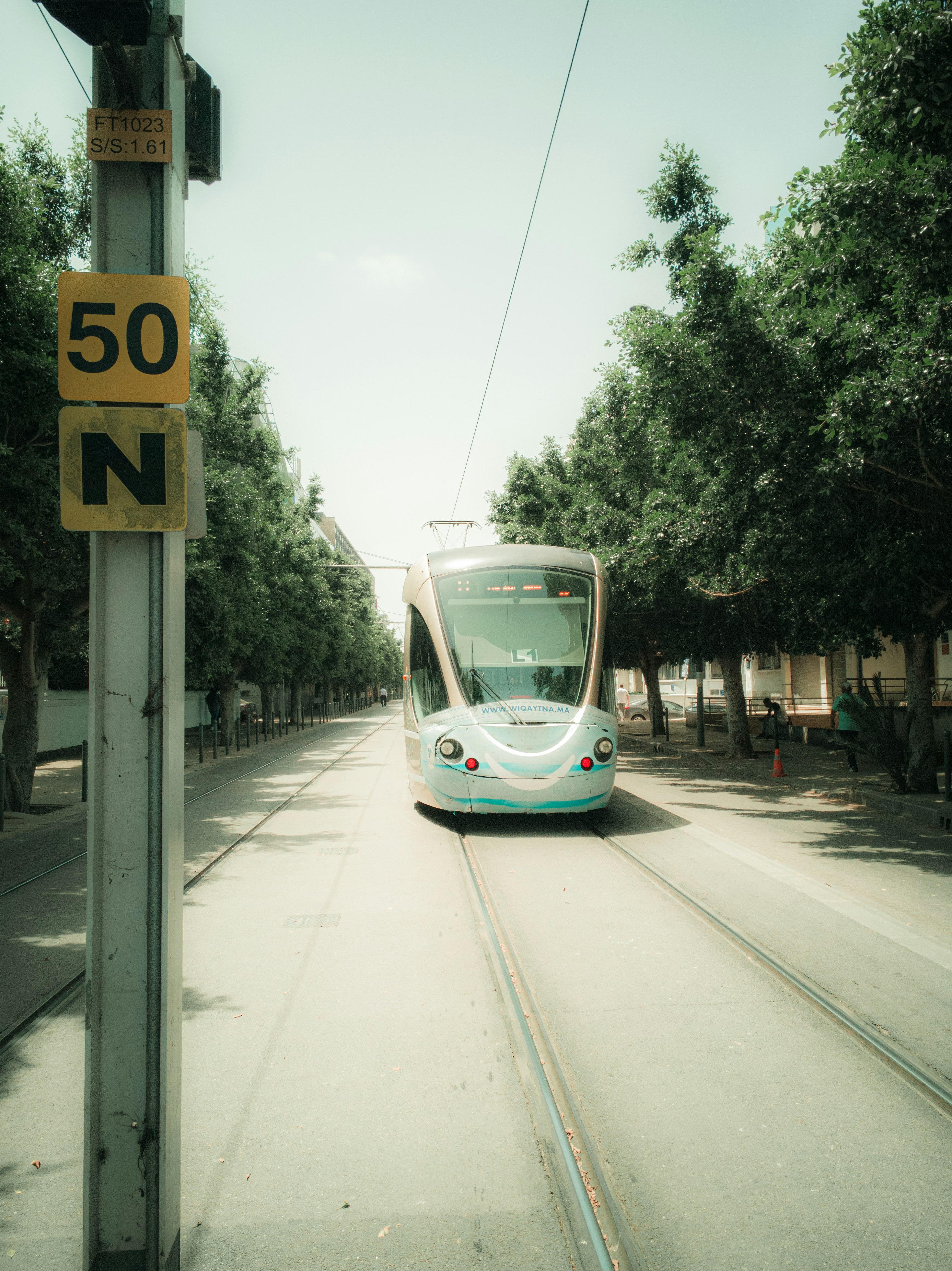 blue and white tram on road during daytime